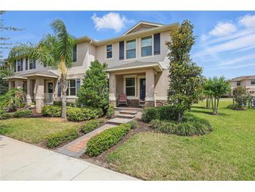 Charming two-story townhome with a beautifully landscaped front yard and inviting entryway at 16163 Pebble Bluff Loop, Winter Garden, FL 34787