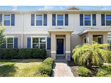 Inviting townhouse featuring a covered entryway, blue shutters and landscaping at 16518 Brook Springs Aly, Winter Garden, FL 34787