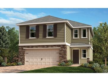 Charming two-story home with stone accents, a manicured lawn, and a neutral color palette at 207 Rivermill Way, Lake Wales, FL 33859