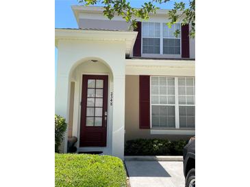 Inviting two-story home featuring a red front door with decorative windows and red shutters at 2348 Silver Palm, Kissimmee, FL 34747