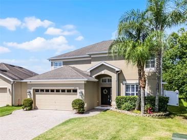 Charming two-story home with a well-maintained lawn, brick driveway, and mature trees at 2411 Sabastian St, Mount Dora, FL 32757