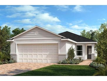 Charming single-story home with a two-car garage, manicured lawn, and classic architectural details at 3293 Rolling Plains Cir, Clermont, FL 34714