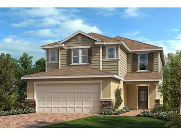 Charming two-story home features a brick-accented facade, a two-car garage, and a manicured lawn at 3389 Rolling Plains Cir, Clermont, FL 34714