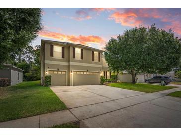 Two-story home featuring a well-manicured lawn, mature landscaping, and a spacious three-car garage at 555 Carey Way, Orlando, FL 32825