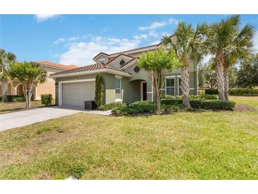 Charming two-story home with a tile roof and lush landscaping featuring mature palm trees at 4201 Oakview Dr, Davenport, FL 33837