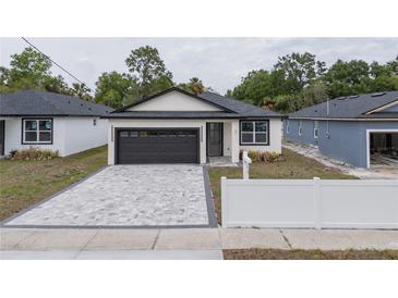 Charming single-story home with a gray brick driveway and a two-car garage at 59 W 10Th St, Apopka, FL 32703