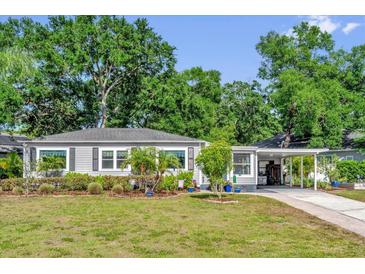 Charming gray home with manicured landscaping and a convenient carport, showcasing curb appeal at 1145 Utah Blvd, Orlando, FL 32803