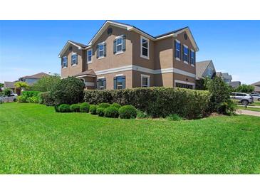 Well-kept lawn enhances this two-story home, featuring dark shutters and trimmed hedges for privacy at 3008 Cardillino Way, Kissimmee, FL 34741