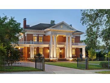 Stately brick home with classic architectural details, towering columns, and a beautifully landscaped front yard at 690 E Church St, Bartow, FL 33830