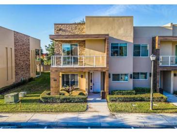 Modern two-story home with a stone accent wall and balcony at 7672 Amazonas St, Kissimmee, FL 34747