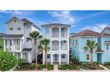 Charming three-story home with double balconies and lush tropical landscaping at 8044 Lost Shaker Ln, Kissimmee, FL 34747