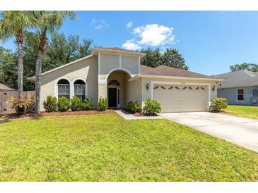 Charming single-story home featuring a well-manicured lawn and attached two-car garage at 830 Grand Hughey Ct, Apopka, FL 32712