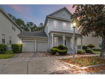 Charming two-story home boasts a well-manicured lawn, inviting porch, and a convenient two-car garage at 1013 Maiden Ter, Celebration, FL 34747