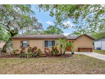Charming single-story home featuring a well-manicured front yard with lush landscaping and mature trees at 150 Debary Dr, Debary, FL 32713