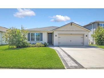 Charming single-story home featuring a well-manicured lawn, a two-car garage, and a welcoming front entrance at 1866 Cassidy Knoll Dr, Kissimmee, FL 34744