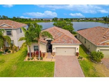 Stunning lakefront home featuring a beautiful tile roof and meticulously manicured landscaping at 2173 Lake Side Ave, Davenport, FL 33837