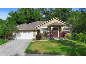 Charming single-story home with a well-manicured lawn, mature landscaping, and attached two-car garage at 4199 Conway Place Cir, Orlando, FL 32812