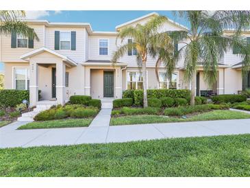 Charming two-story townhome featuring lush landscaping and a welcoming entrance, perfect for a serene suburban lifestyle at 6013 Blue Lily Way, Winter Garden, FL 34787