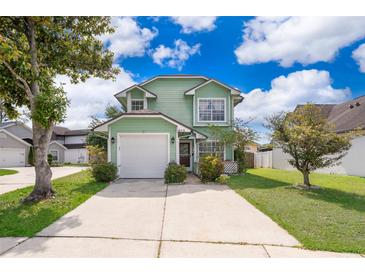 Inviting two-story home with a well-manicured lawn, concrete driveway, and attached garage at 645 Upperriver Ct, Orlando, FL 32828
