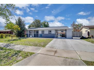 Charming single story home with a carport and a cozy screened in front porch and well-maintained front yard at 6464 Inca St, Orlando, FL 32807