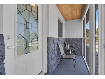 Cozy screened front porch with chairs and a decorative glass front door at 6464 Inca St, Orlando, FL 32807