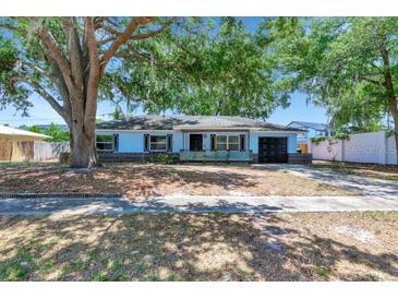 Charming single-story home featuring an attached garage, mature tree, and brick accents at 7507 Duo Lakes Dr, Orlando, FL 32810