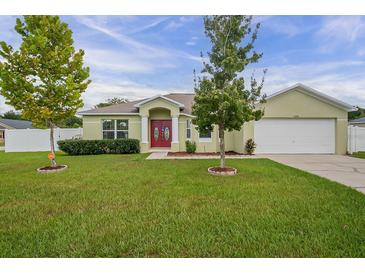Charming single-story home with a well-maintained lawn and inviting red double door entrance and neutral paint at 8398 Split Creek Cir, Lakeland, FL 33809