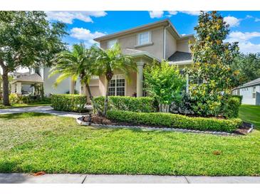 Charming two-story home with landscaped front yard, palm trees, and manicured hedges at 8448 Greenbank Blvd, Windermere, FL 34786