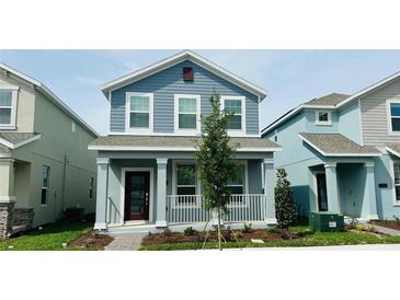 Charming two-story home features a covered front porch and well-maintained landscaping at 11296 Listening Dr, Orlando, FL 32832