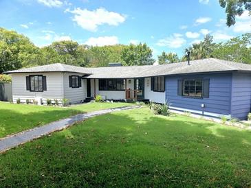 Charming single-story home featuring a well-manicured lawn and nicely contrasting exterior paint colors at 905 W 11Th Ave, Mount Dora, FL 32757