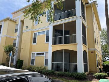Three-story yellow building with screened-in patios and well-maintained landscaping at 1420 Lake Shadow Cir # 9207, Maitland, FL 32751