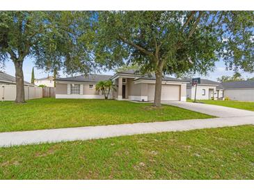 Charming single-story home featuring a well-manicured lawn, mature trees, and attached two car garage at 360 Coventry Estate Blvd, Deltona, FL 32725