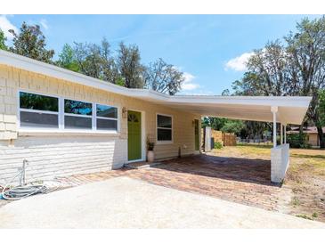 Home exterior featuring carport, neutral paint, green door, and brick accents at 2637 Florence St, Orlando, FL 32818