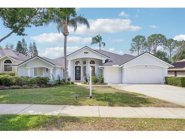 Charming single-story home with a well-manicured lawn, a three-car garage and a welcoming front entrance at 336 Plantation Club Dr, Debary, FL 32713