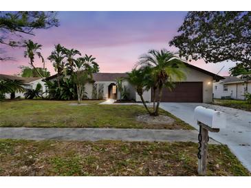 Charming single-story home featuring a well-manicured lawn and beautiful tropical landscaping at 1026 Manchester Cir, Winter Park, FL 32792
