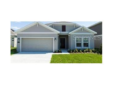 Charming single-story home with a well-maintained lawn, neutral paint, and an attached two-car garage at 1163 James Paul Rd, Davenport, FL 33837