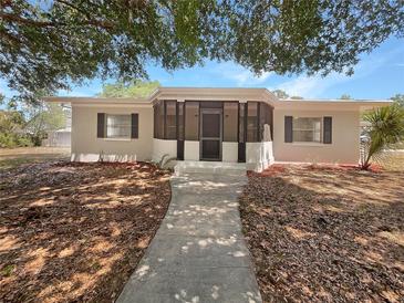 Charming single-story home with a screened-in porch and walkway leading to the front door at 1249 12Th St, Clermont, FL 34711