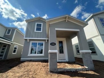 Charming two-story home featuring a covered porch with stylish gray paint and white trim at 1360 Twelve Oaks Rd, St Cloud, FL 34771