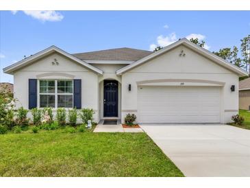 Charming single-story home with a well-manicured lawn, blue shutters, and a two-car garage at 149 Hickory Course Cir, Ocala, FL 34472