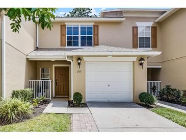 Charming townhome featuring a one car garage, wooden shutters and a cozy front porch at 207 Sterling Springs Ln, Altamonte Springs, FL 32714