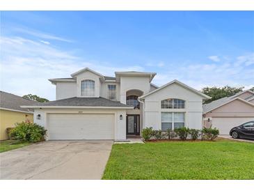 Inviting two-story home with a manicured lawn and attached two-car garage at 2889 Blooming Alamanda Loop, Kissimmee, FL 34747
