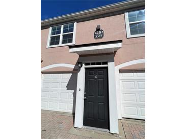 Charming townhome entrance with a black front door and attached one-car garage at 3337 Soho St # 205, Orlando, FL 32835
