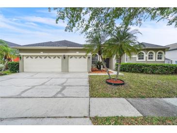 Charming single-Gathering home featuring a three-car garage, landscaped yard, and mature trees at 339 Hammock Dunes Pl, Orlando, FL 32828