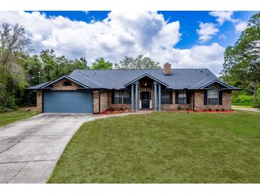 Charming brick home featuring a spacious front lawn and a two-car garage at 810 Alex Ln, Deltona, FL 32738