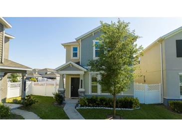 Charming two-story home featuring a well-maintained lawn and inviting front porch with beautiful landscaping at 10038 Verse Aly, Winter Garden, FL 34787