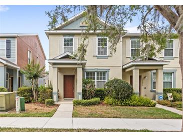 Inviting two-story townhome with neutral paint, decorative shutters, and manicured landscaping at 12977 Borland St, Windermere, FL 34786