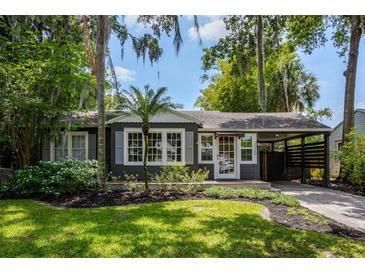 Charming home exterior featuring mature landscaping, a covered carport and classic architectural details at 2020 Palmer St, Orlando, FL 32803