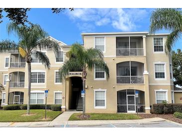 Inviting condo exterior boasts screened balconies and lush palm trees against a blue sky at 2302 Butterfly Palm Way # 105, Kissimmee, FL 34747