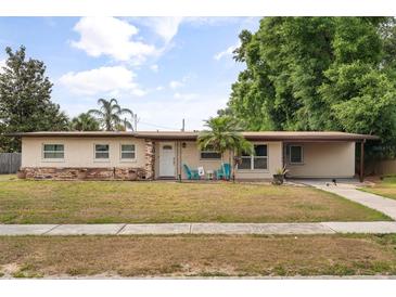 Charming single-story home featuring a well-kept lawn, quaint sitting area, and a neutral color palette at 5606 Eggleston Ave, Orlando, FL 32810