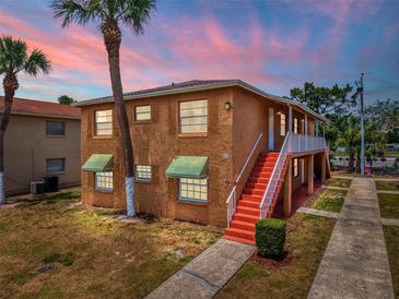 Charming two-story home featuring beautiful stucco siding, complemented by lush landscaping, and a inviting stairway at 707 Michigan Ct # 2, St Cloud, FL 34769